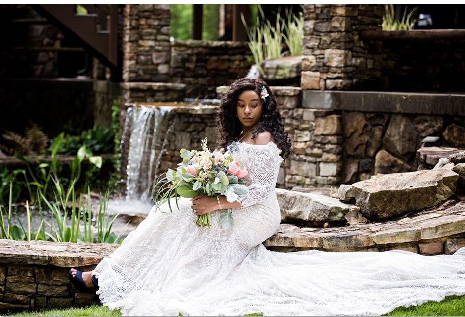 Bride by the waterfall with bouquet