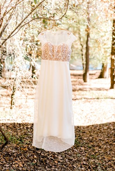 Wedding dress hanging among autumn trees